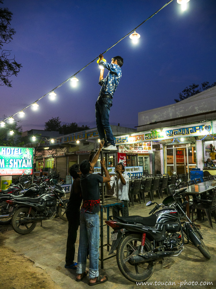 Remplacement d'une ampoule sur une guirlande lumineuse dans une rue en Inde