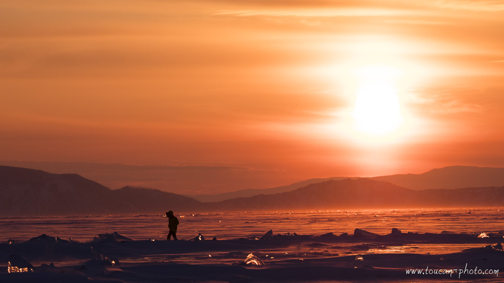Marche sur le lac Baïkal gelé au coucher du soleil