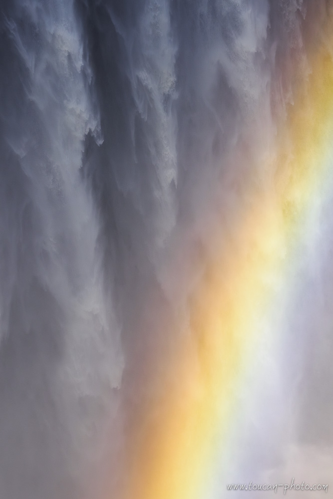 Rainbow in the spray in front of Victoria Falls in Zimbabwe